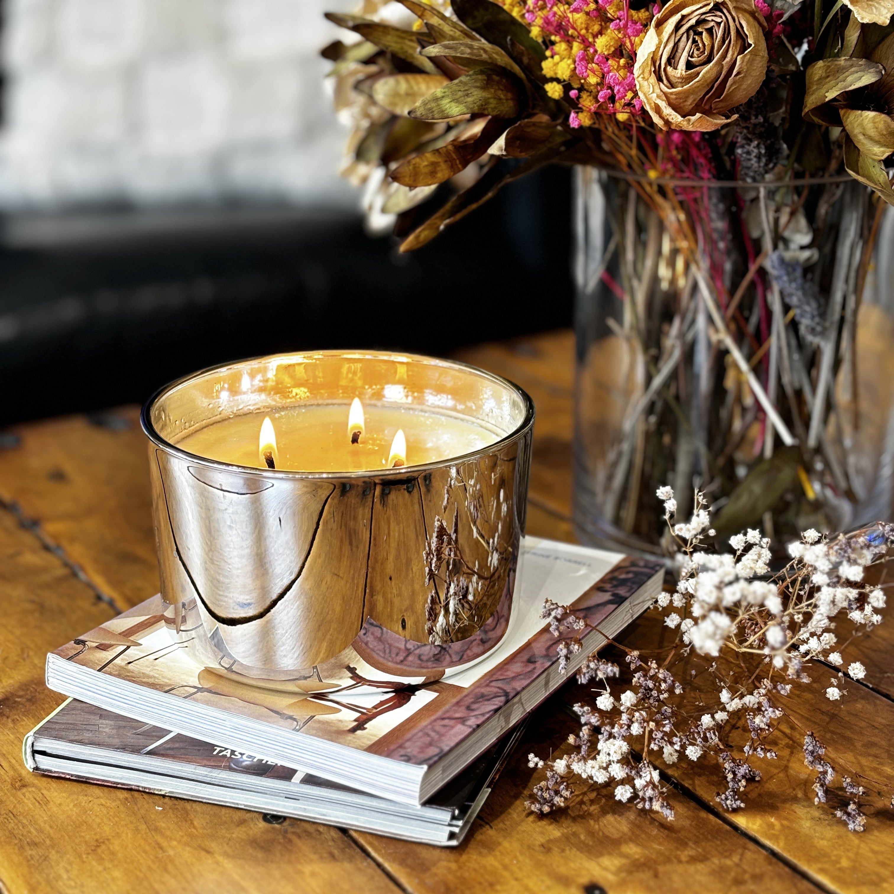 Shinny Silver Scented candle sitting on books