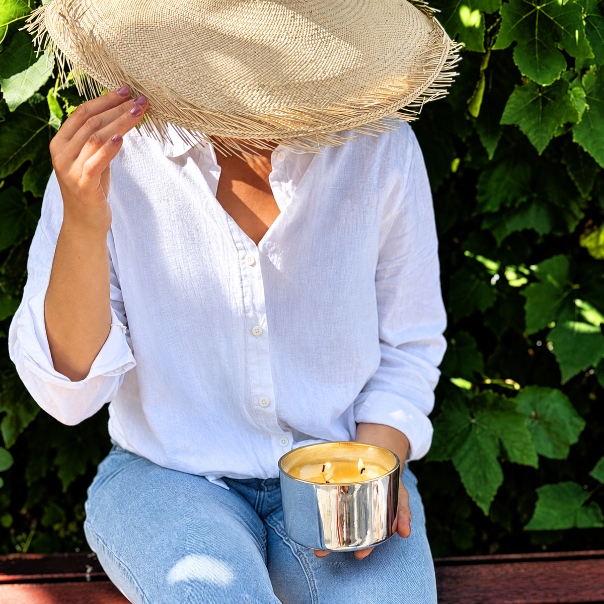 Lady in white top holding a silver scented Candle