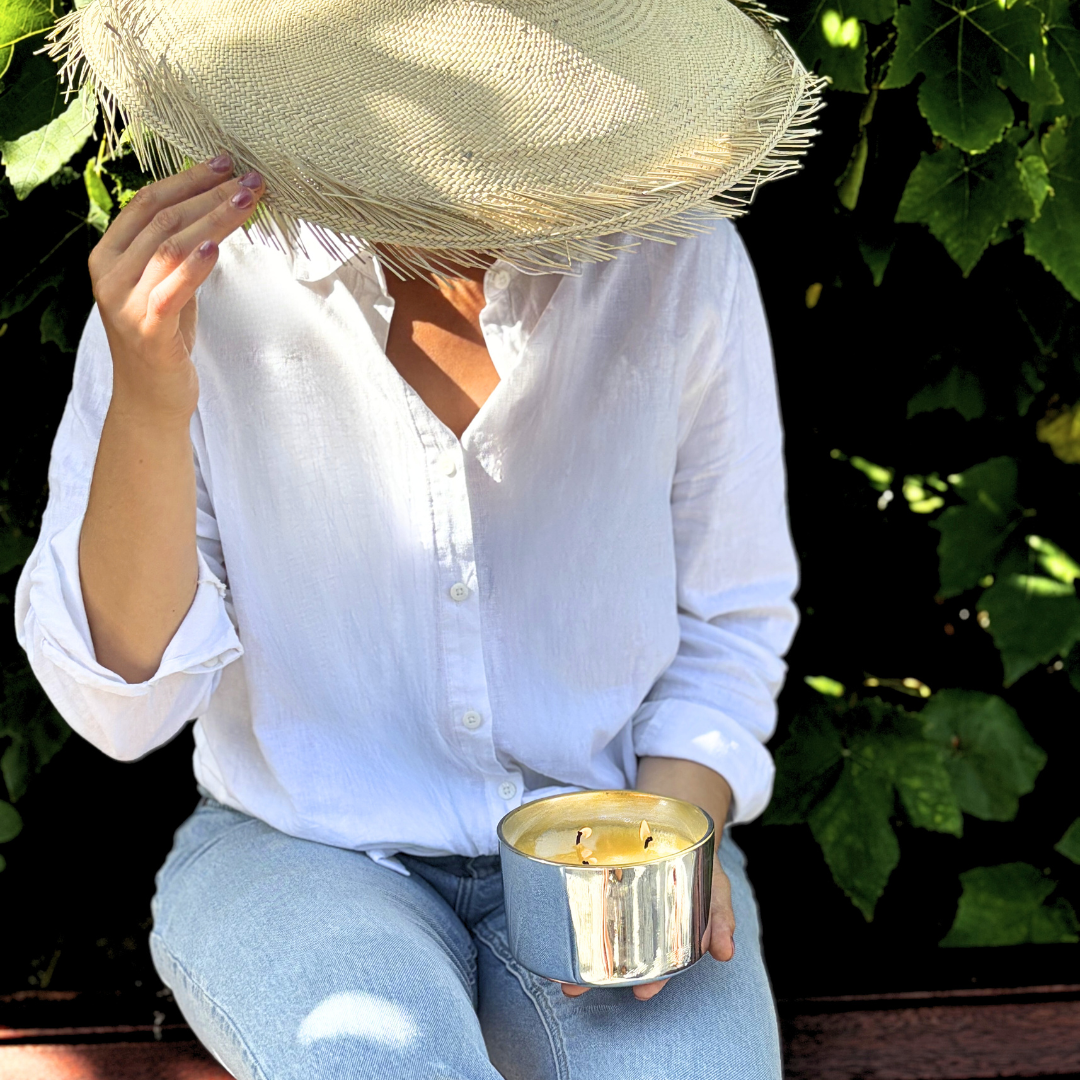 Lady in white top holding a silver scented Candle