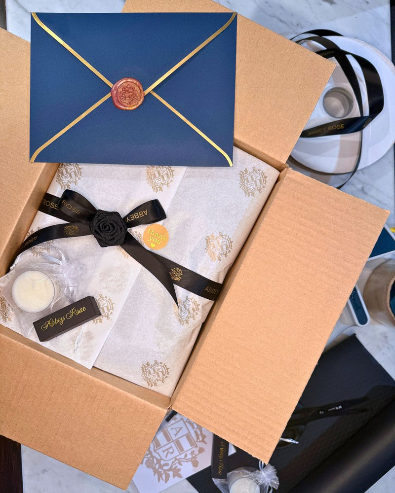 Abbey Rose luxury gift wrapping with gold crest tissue paper, black satin ribbon, wax sealed card and complimentary soy tealight, New Zealand